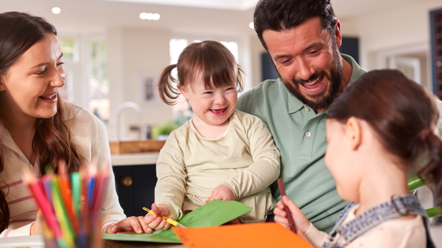 A family of four sitting around a table and crafting together